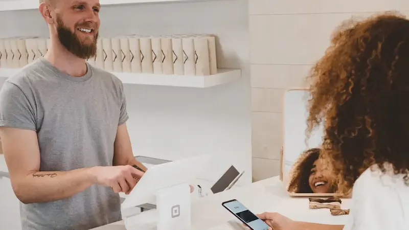 Small shop owner serving a customer at the counter