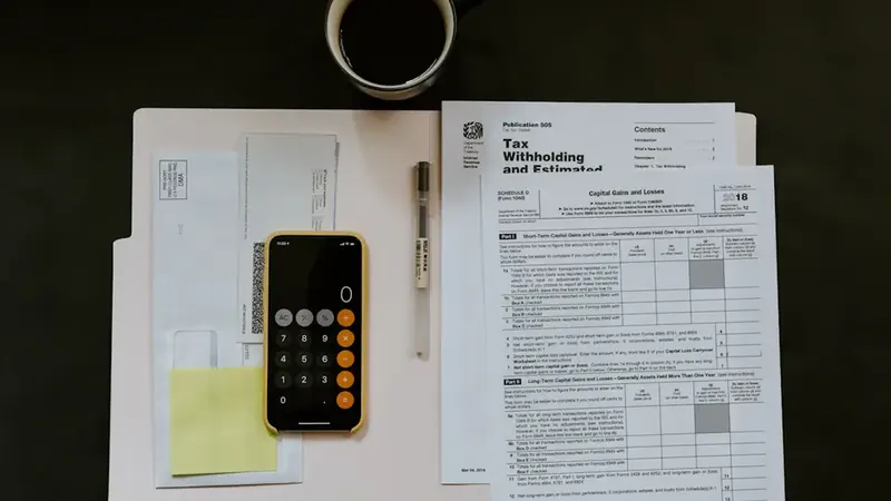 Calculator, coffee and paperwork on a desk — working out a website budget